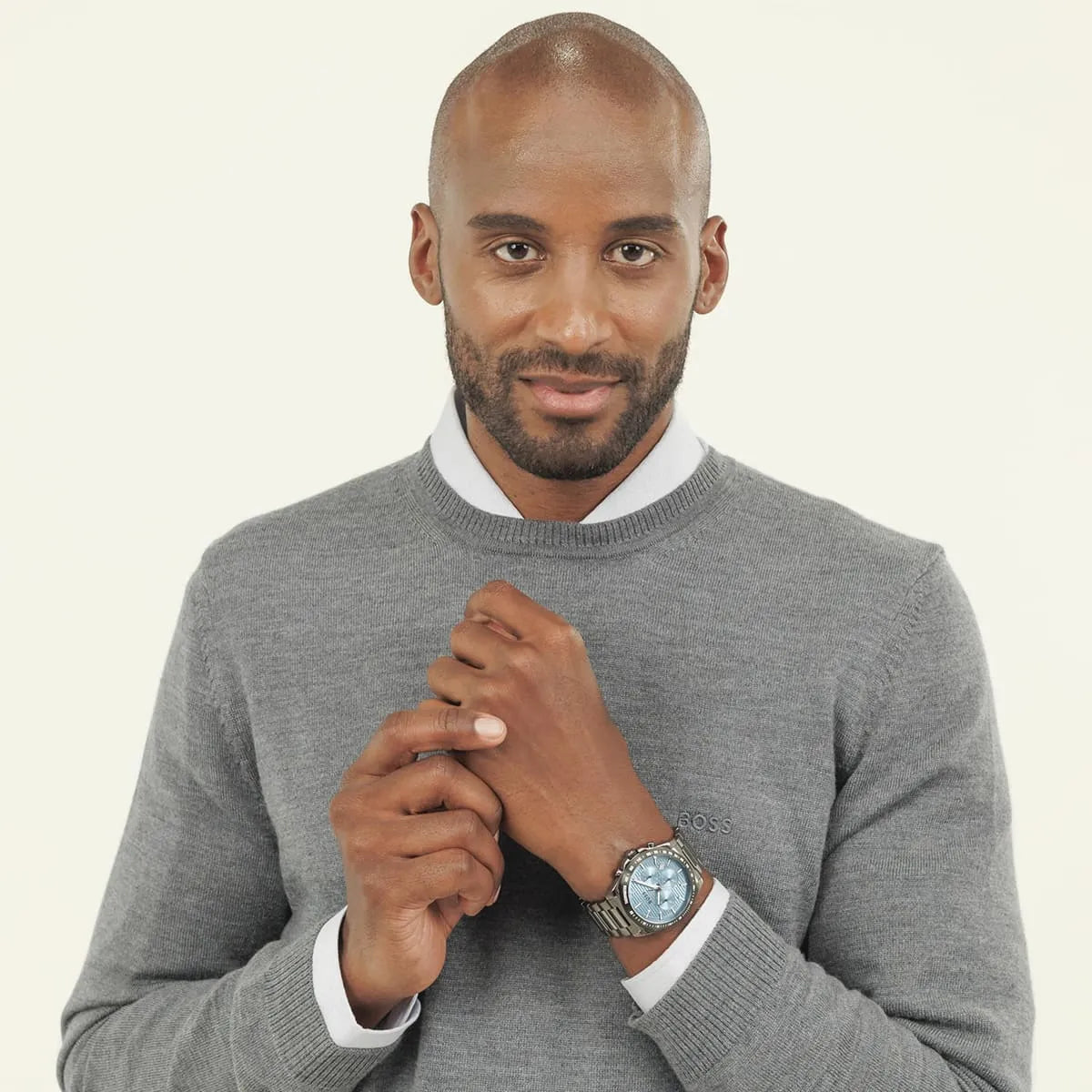Man wearing Hugo Boss Strike watch with gray sweater and white shirt cuff