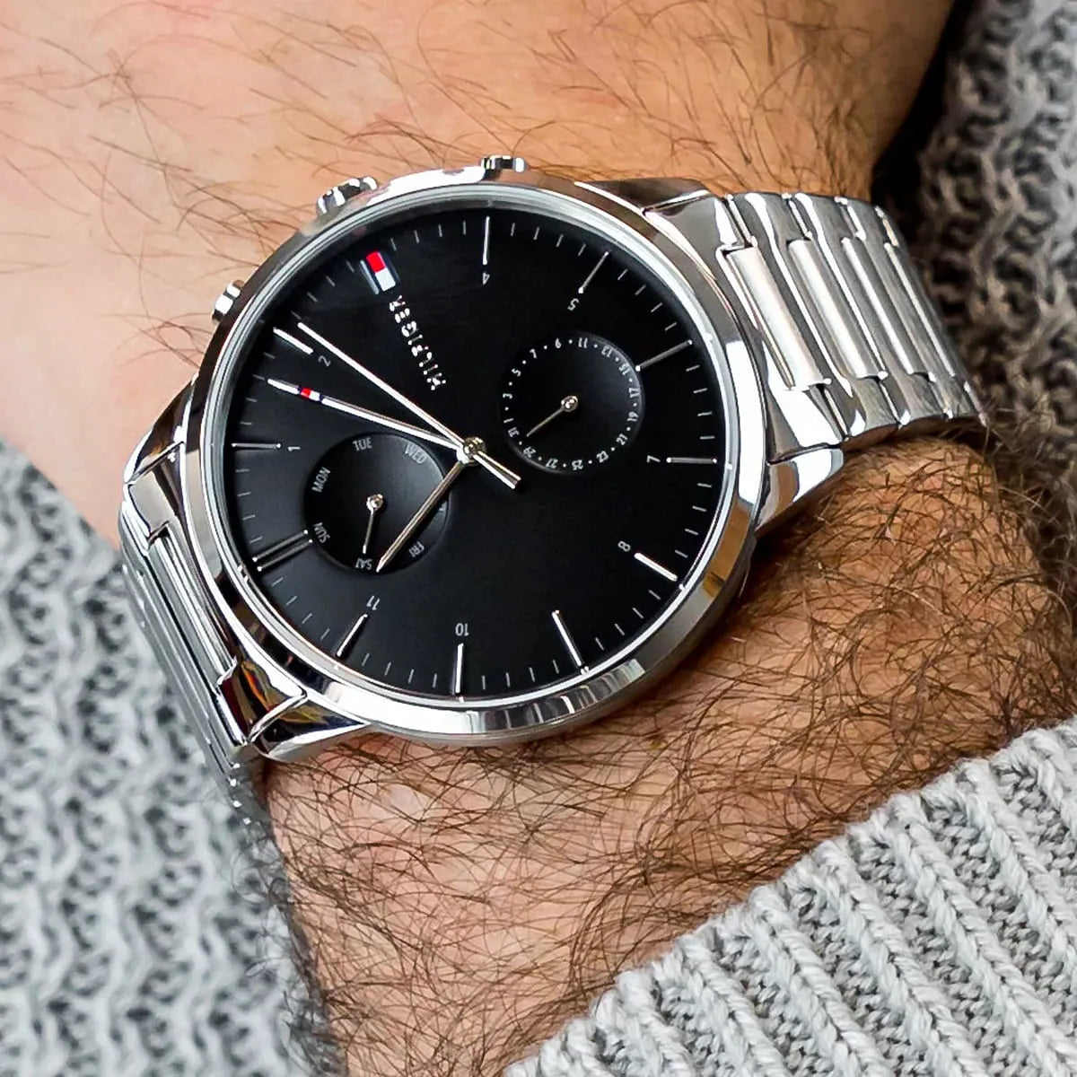Tommy Hilfiger 1710407 chronograph watch on wrist with black dial and metal bracelet