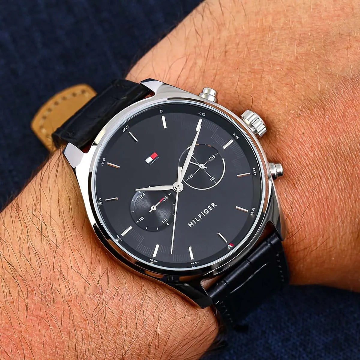 Tommy Hilfiger black dial watch worn on wrist with light background
