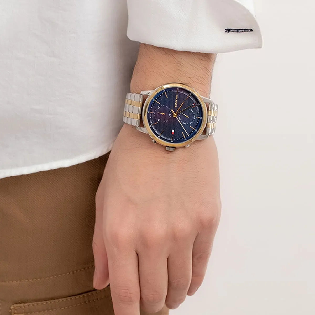 Tommy Hilfiger two-tone watch on wrist with navy blue dial and gold chronograph hands