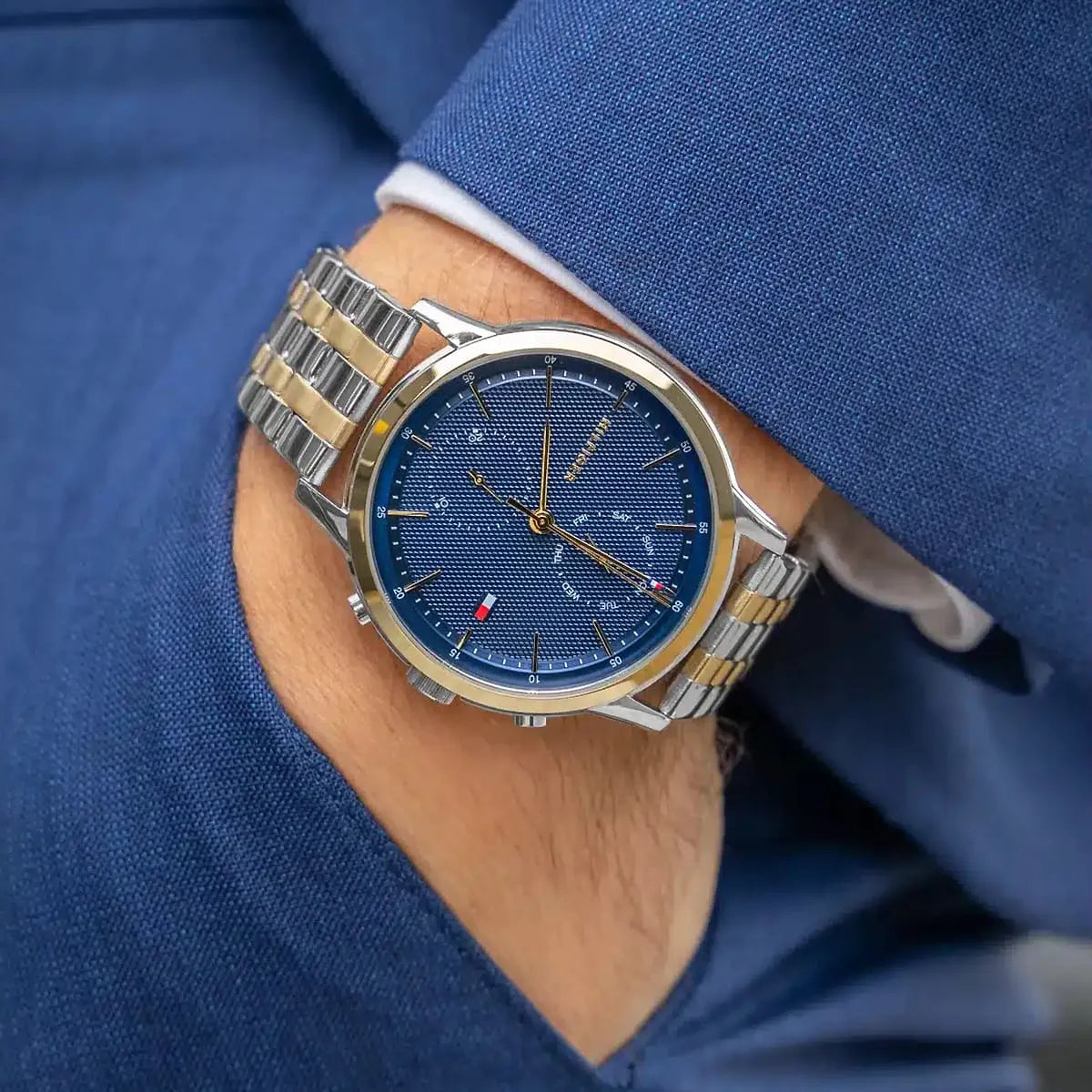 Tommy Hilfiger chronograph watch on wrist with two-tone bracelet and blue textured dial