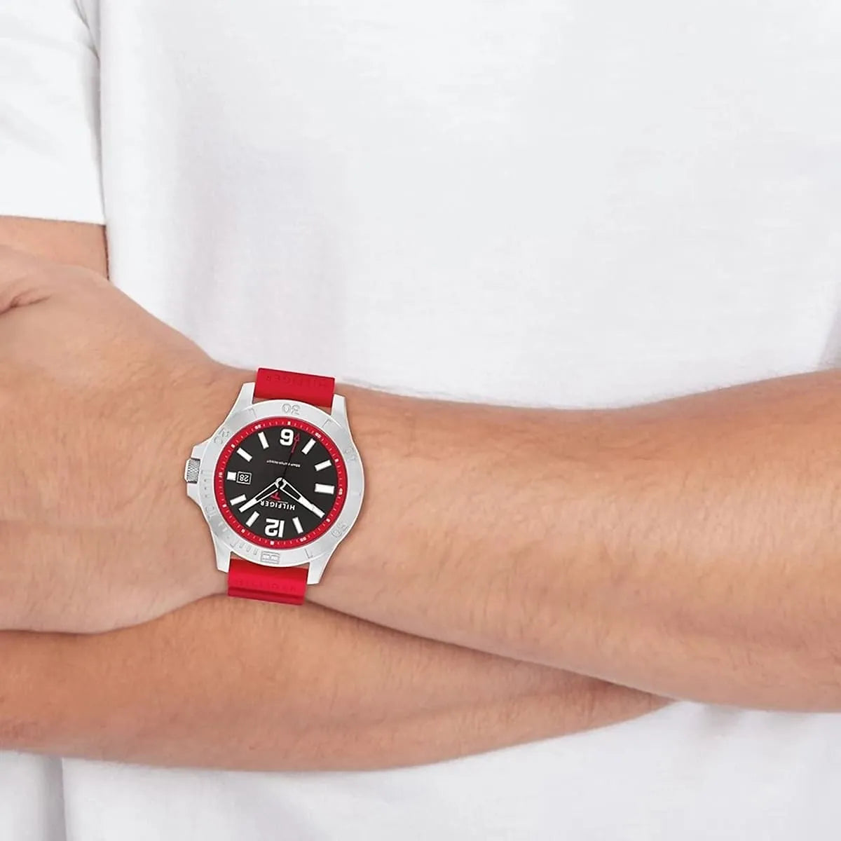 Tommy Hilfiger watch on wrist, worn over white shirt sleeve, red strap detail visible