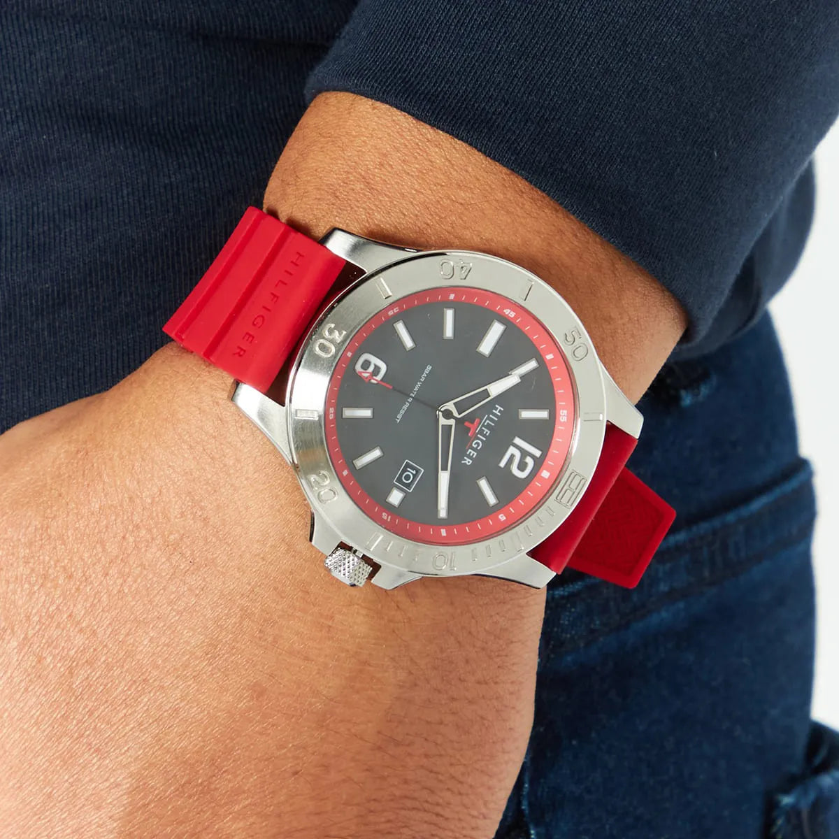 Tommy Hilfiger watch worn on wrist, showing red strap and black dial with red bezel