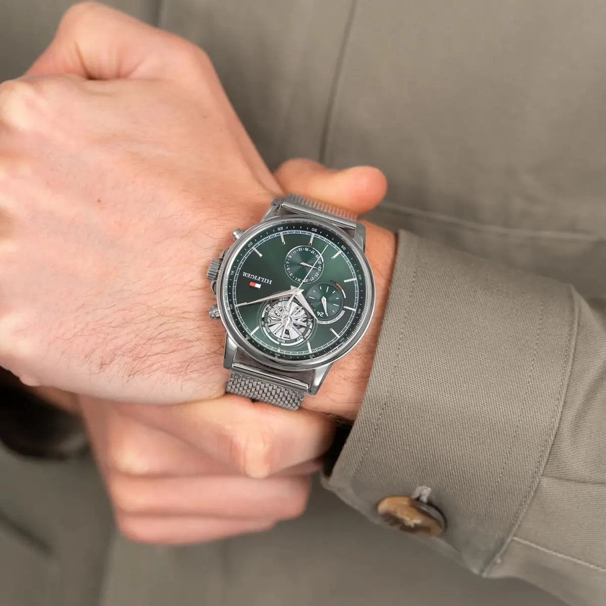 Tommy Hilfiger chronograph watch with green dial worn on wrist, silver mesh strap visible