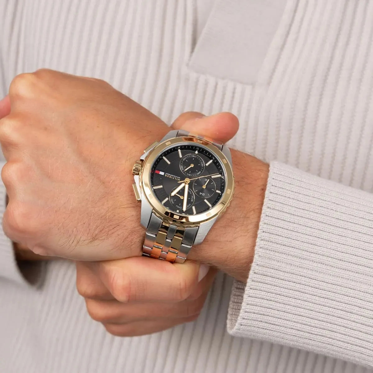 Tommy Hilfiger two-tone watch worn on wrist with grey dial and gold bezel