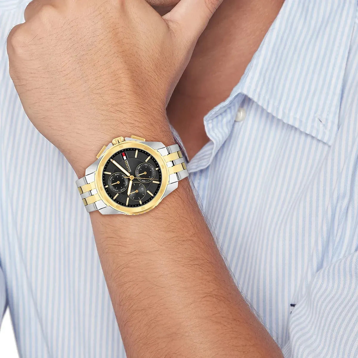 Two-tone Tommy Hilfiger watch on wrist showing full strap and grey chronograph dial