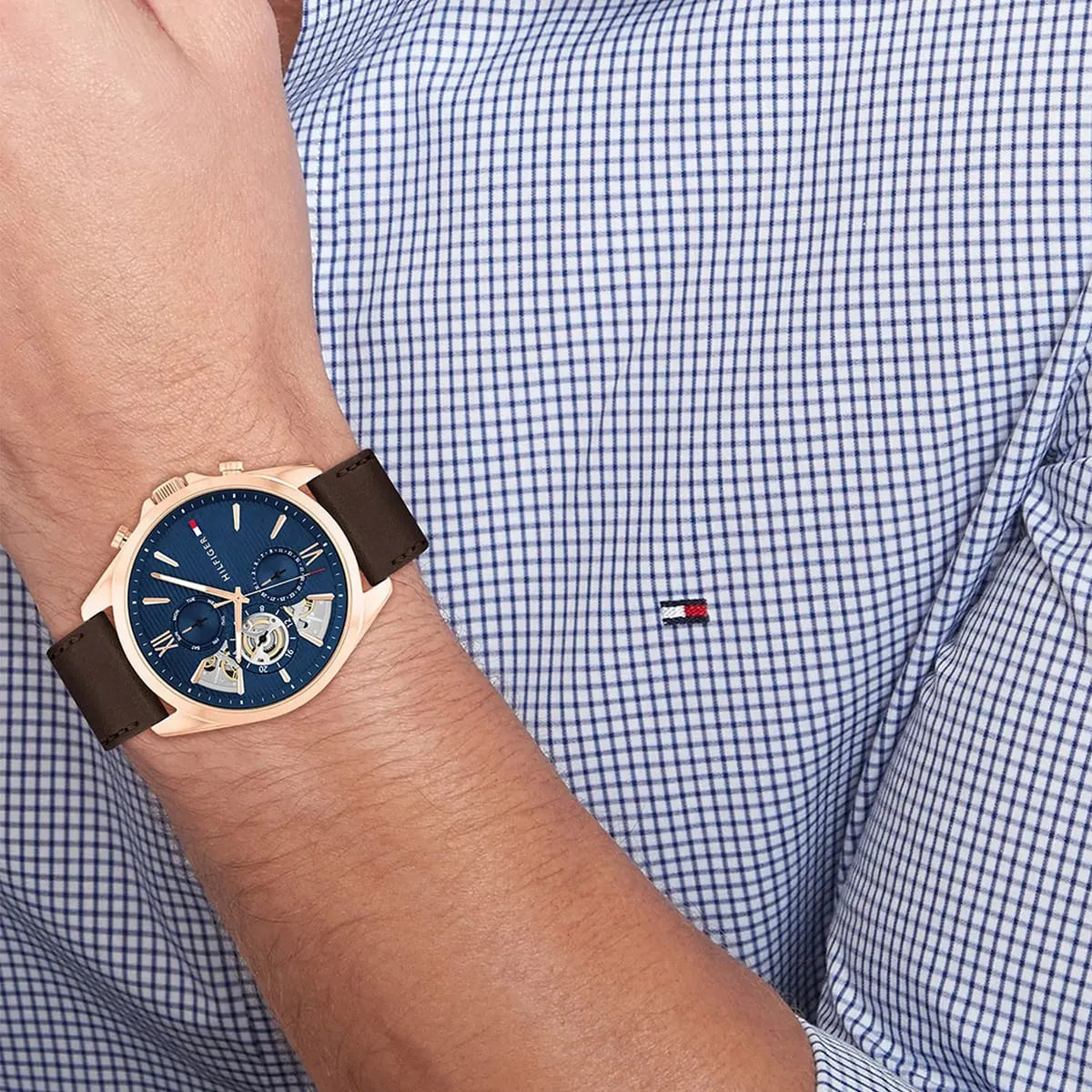 Wrist shot of Tommy Hilfiger Baker men's watch with checkered shirt sleeve
