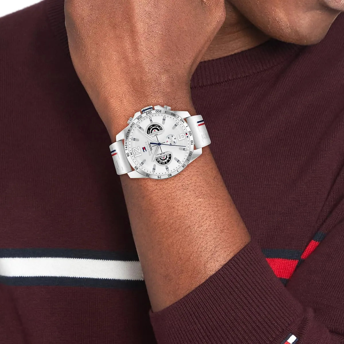 Tommy Hilfiger Decker watch worn on wrist showing white dial and rubber strap with red and blue striping