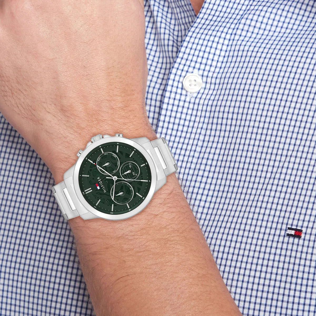 Tommy Hilfiger green dial chronograph watch worn on wrist with blue checkered shirt