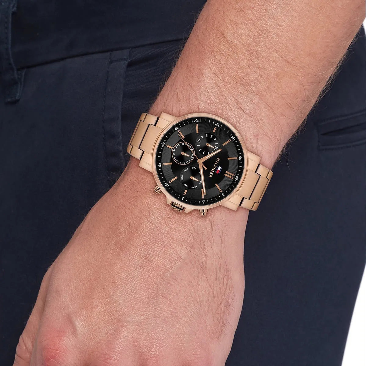 Tommy Hilfiger chronograph watch worn on wrist with black dial and rose gold bracelet