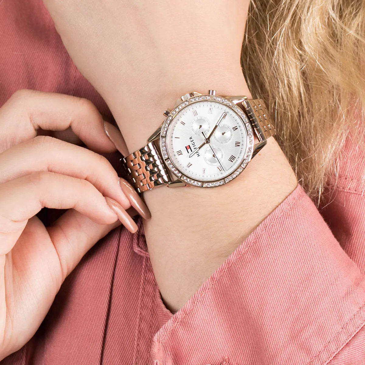 Tommy Hilfiger Ari watch worn on wrist with pink sleeve