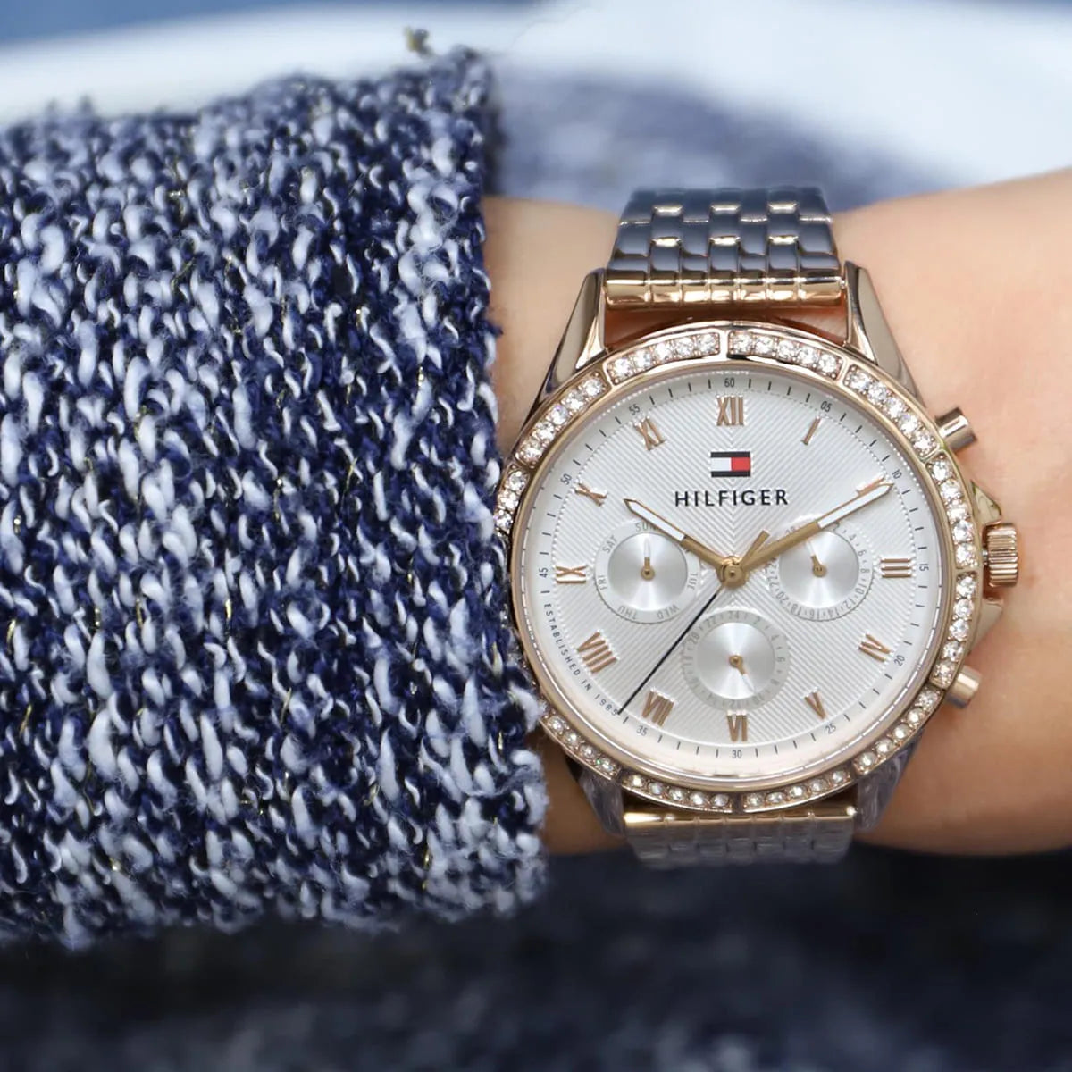 Tommy Hilfiger Ari watch worn on wrist with navy sweater