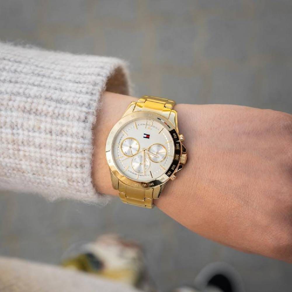Tommy Hilfiger gold chronograph watch on wrist styled with cream sweater