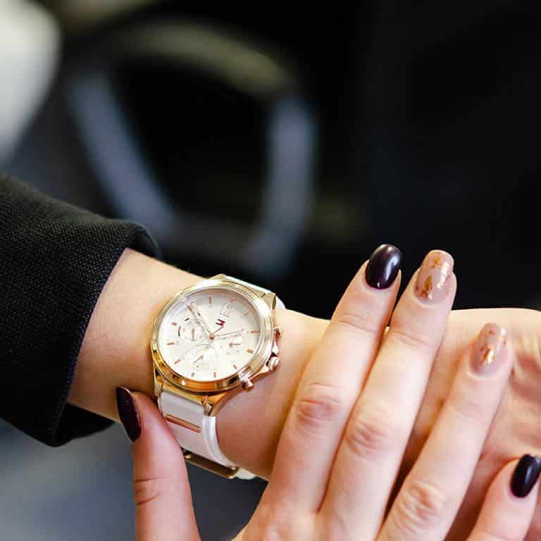 Women wearing Tommy Hilfiger chronograph watch with white strap on wrist