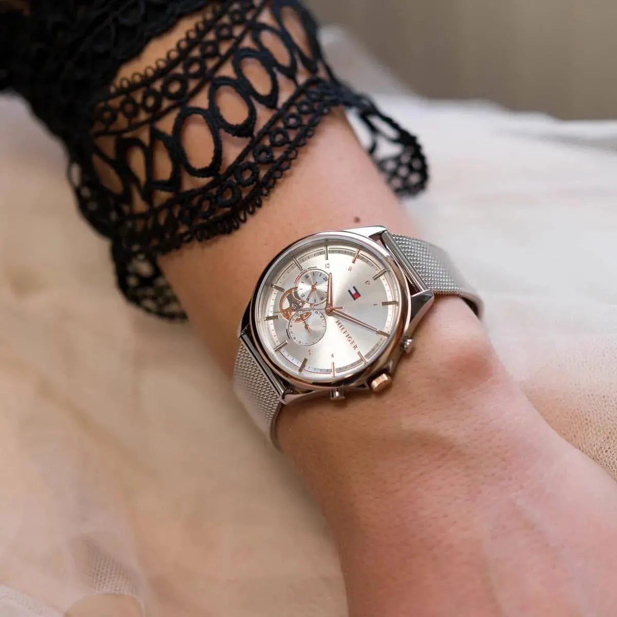Tommy Hilfiger women's watch on wrist with lace cuff detail, displaying dial and rose gold accents