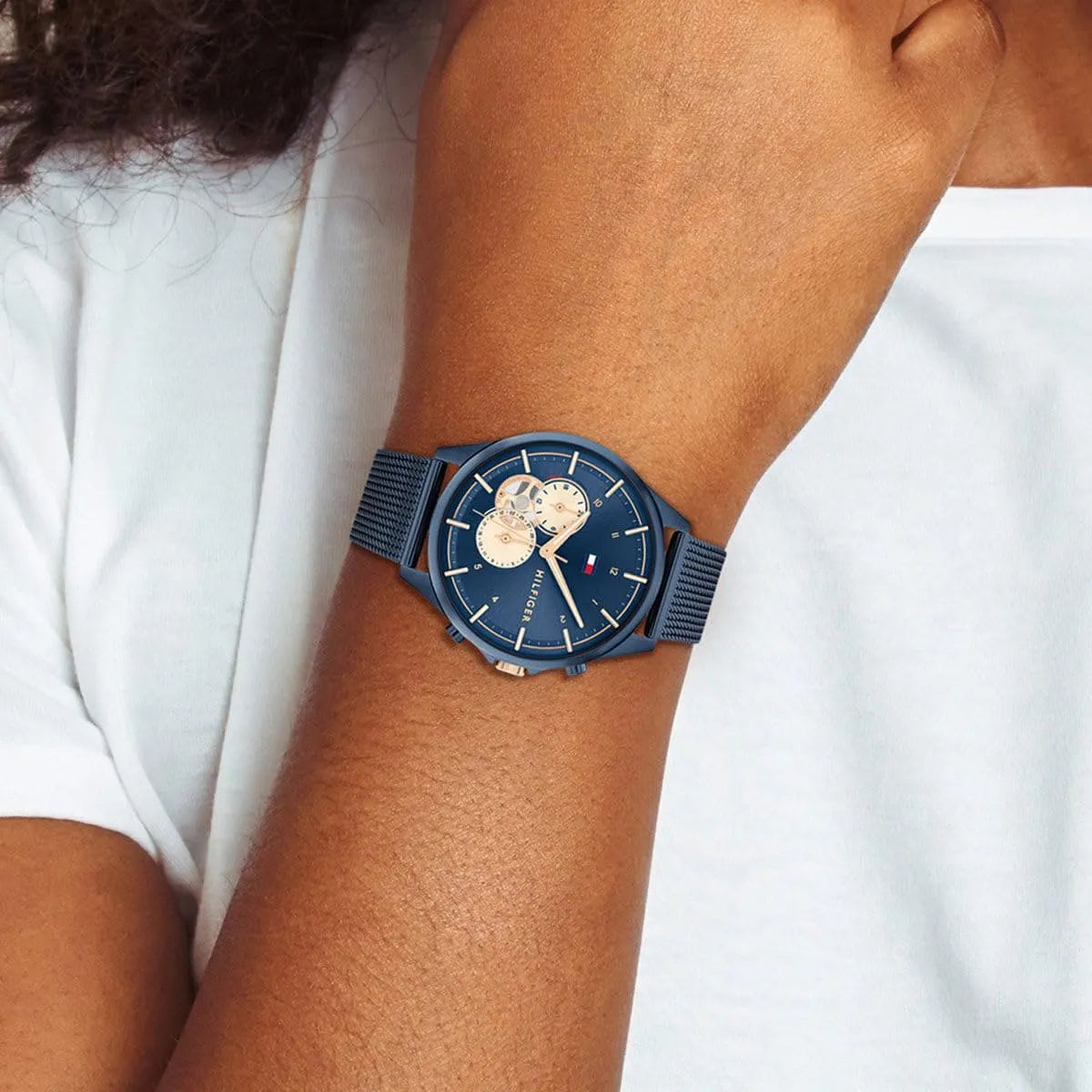 Tommy Hilfiger women's watch on wrist with navy mesh strap and blue dial