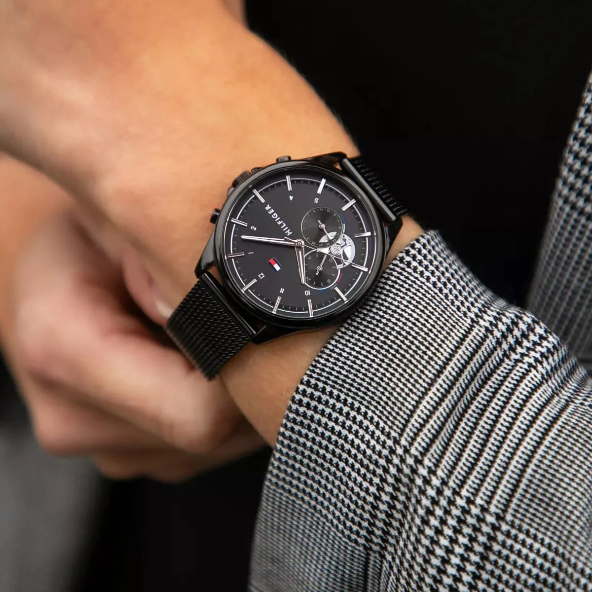 Tommy Hilfiger Quinn watch worn on wrist with black mesh strap
