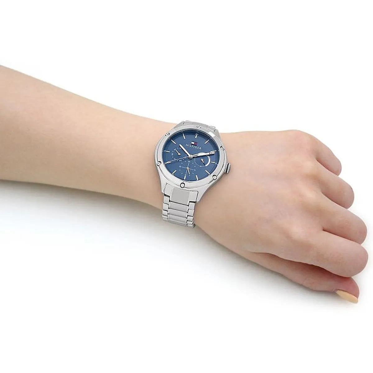 Tommy Hilfiger chronograph watch worn on wrist with blue dial and silver bracelet