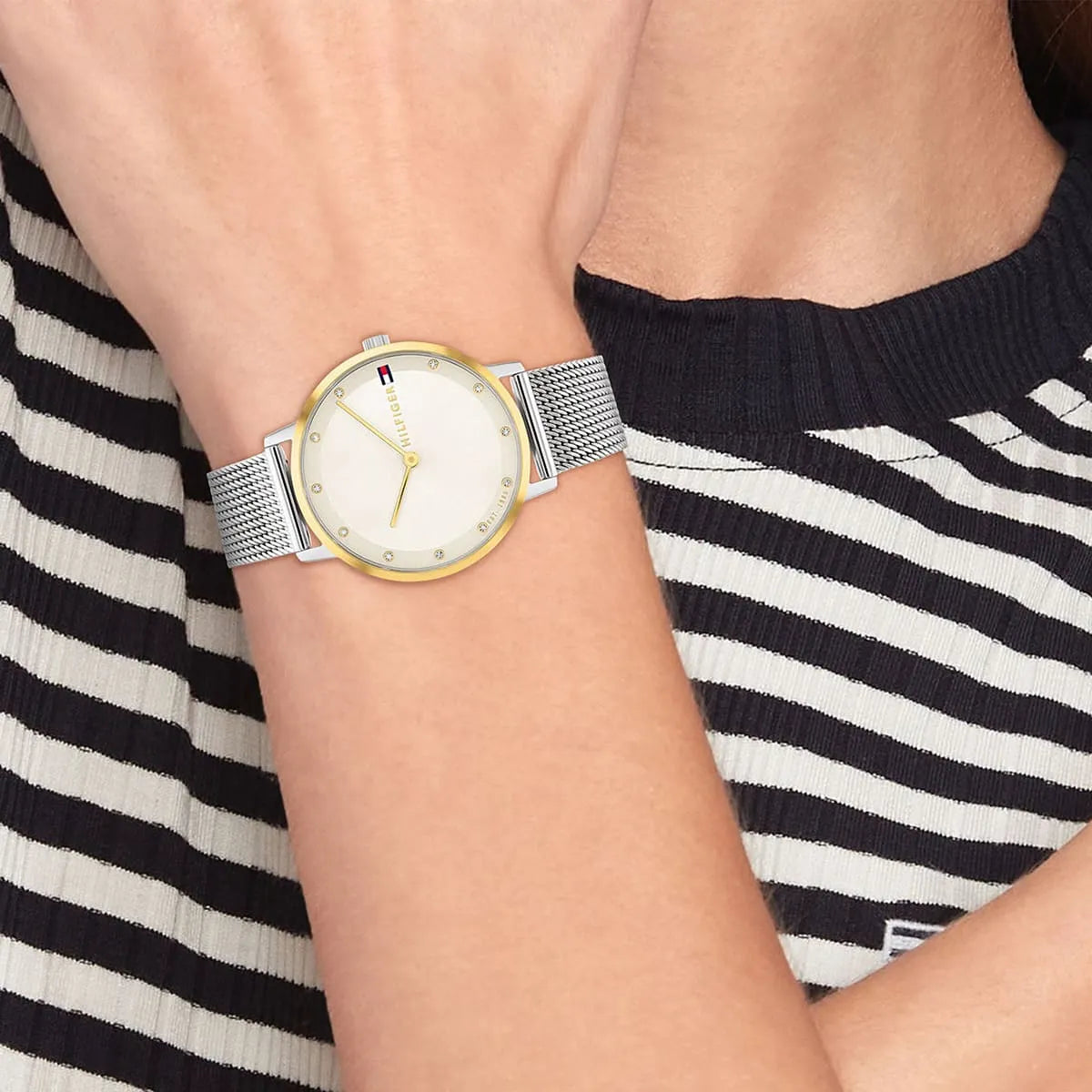 Tommy Hilfiger watch on wrist showing champagne dial with gold bezel and mesh bracelet