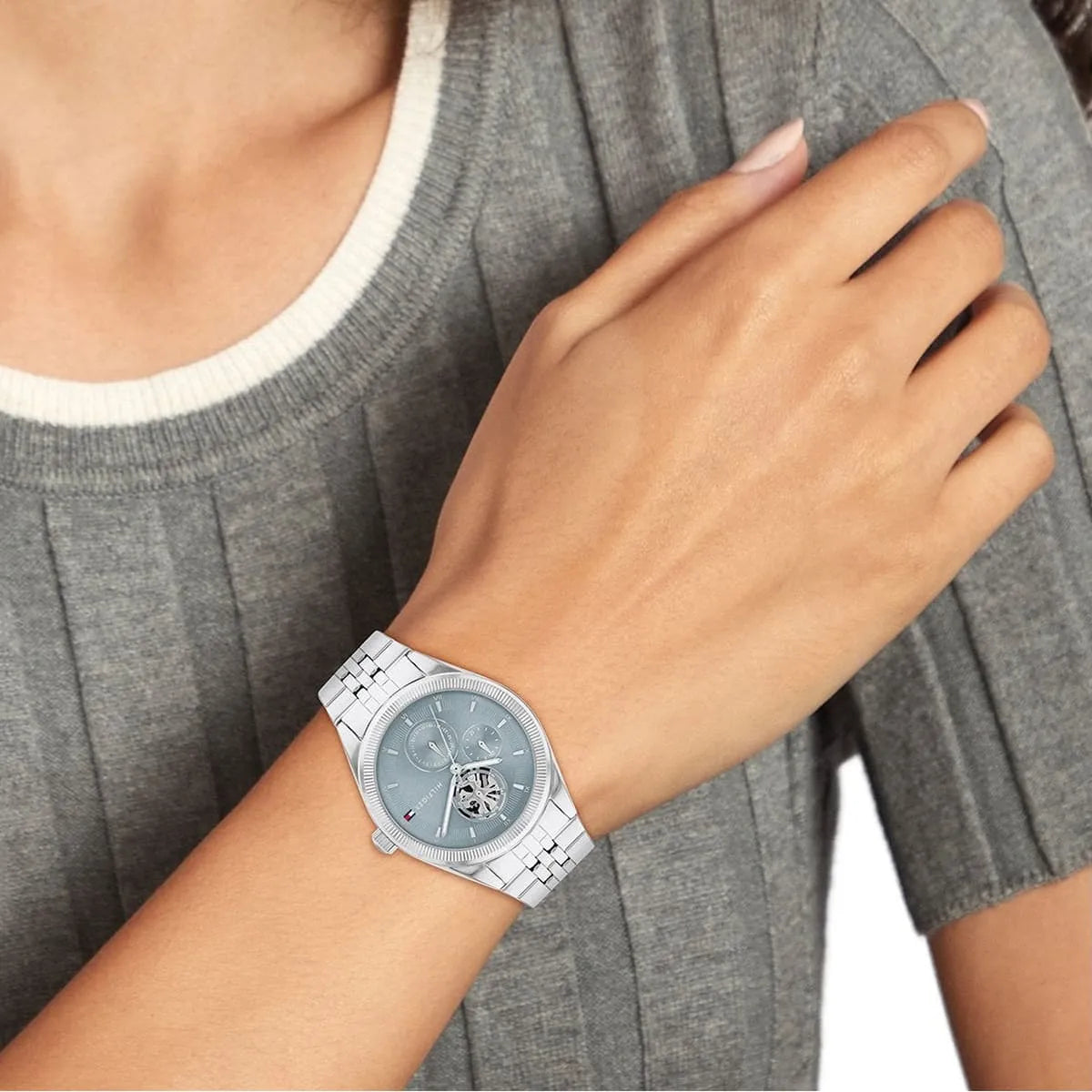 Tommy Hilfiger Monica watch displayed on woman's wrist showing blue dial and skeleton window