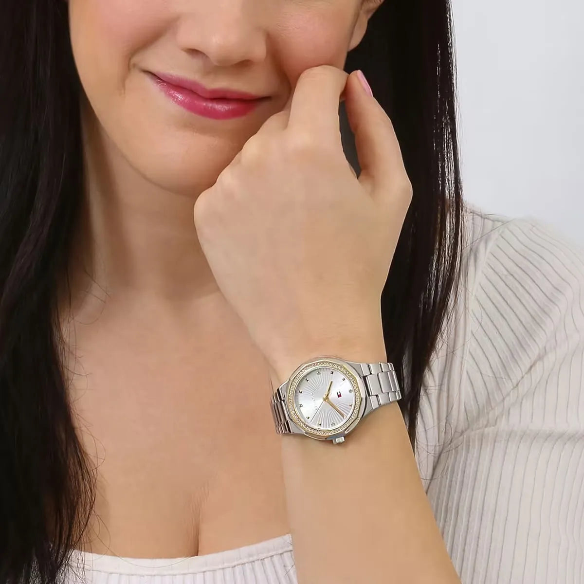Woman wearing Tommy Hilfiger women's watch with silver dial and metal bracelet on wrist