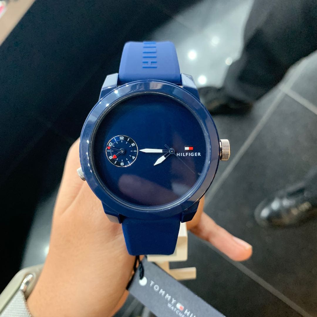 Close-up of Tommy Hilfiger men's sport watch on wrist with navy blue case and dial