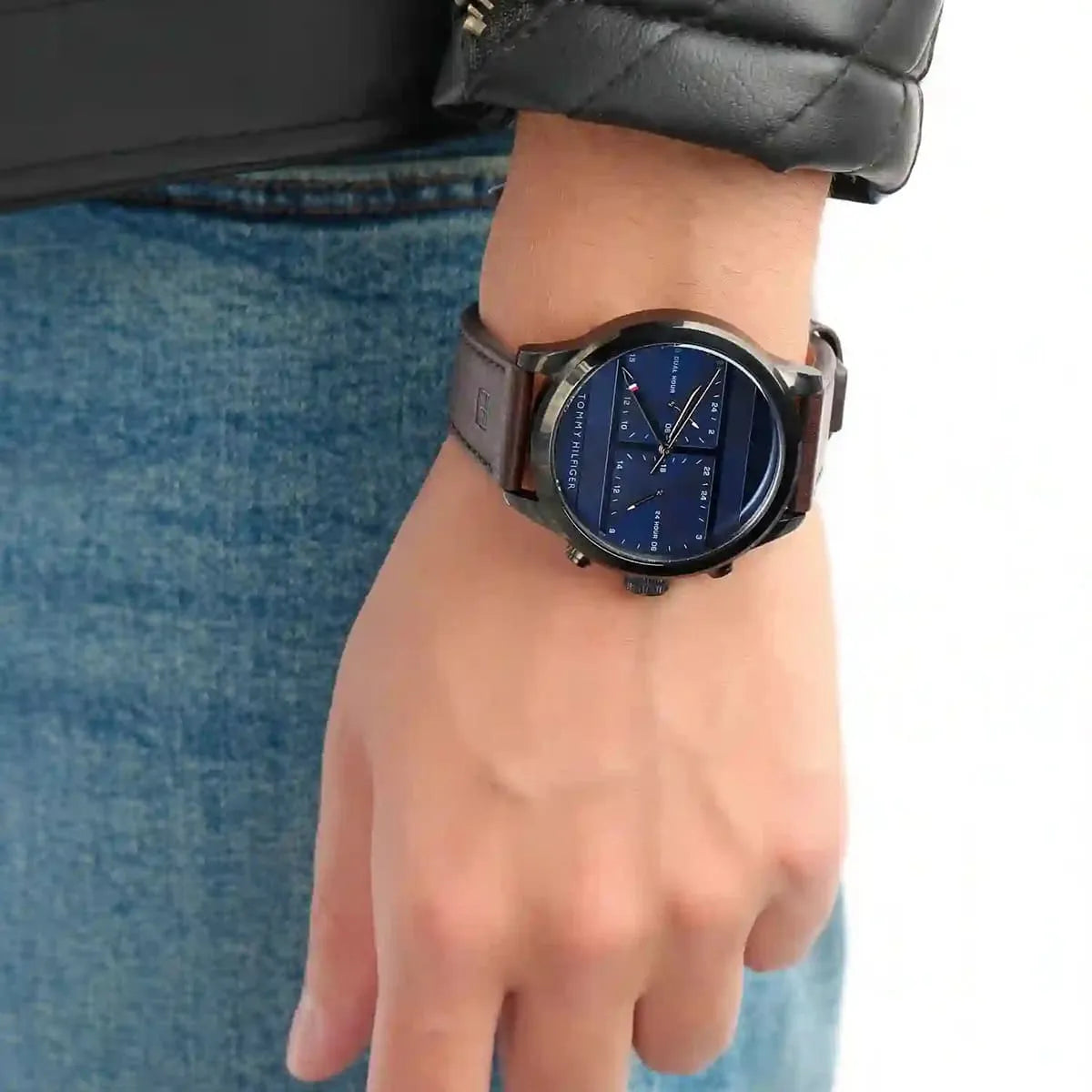 Tommy Hilfiger watch worn on wrist with blue dial and brown leather strap