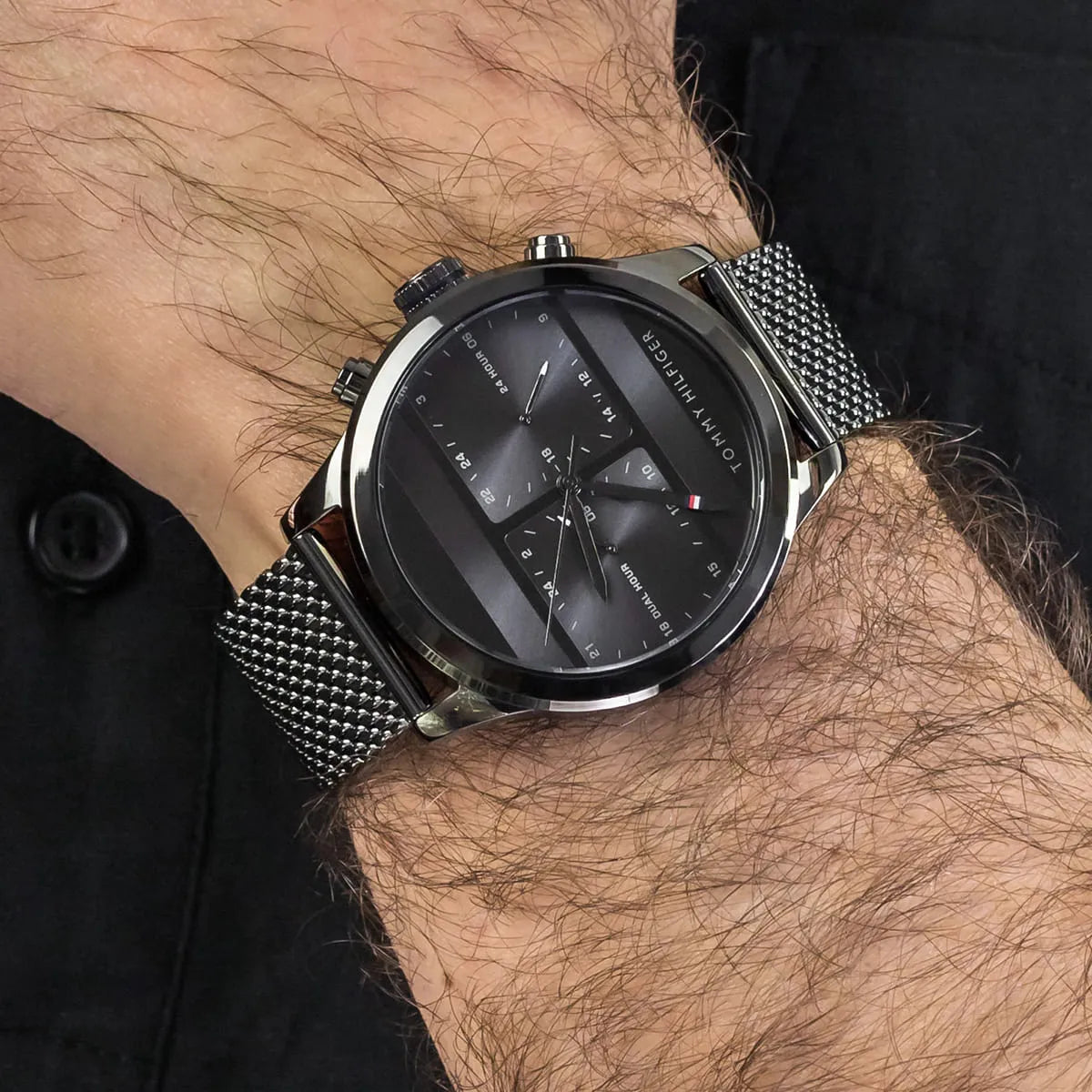 Tommy Hilfiger 1791597 grey dial watch on male wrist showing gunmetal finish and mesh strap