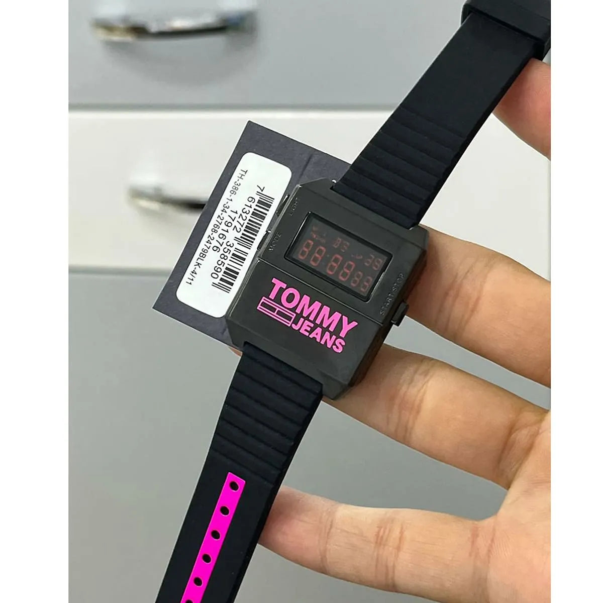 Tommy Hilfiger Jeans digital chronograph watch worn on wrist with black and pink strap