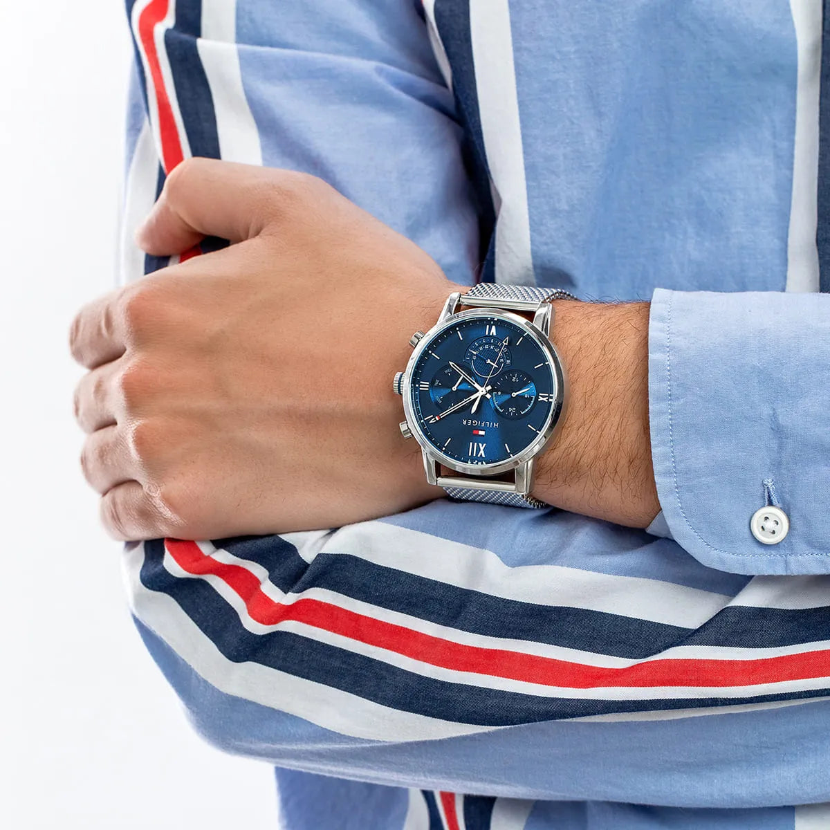 Tommy Hilfiger multifunction watch on wrist showing blue dial and silver mesh strap