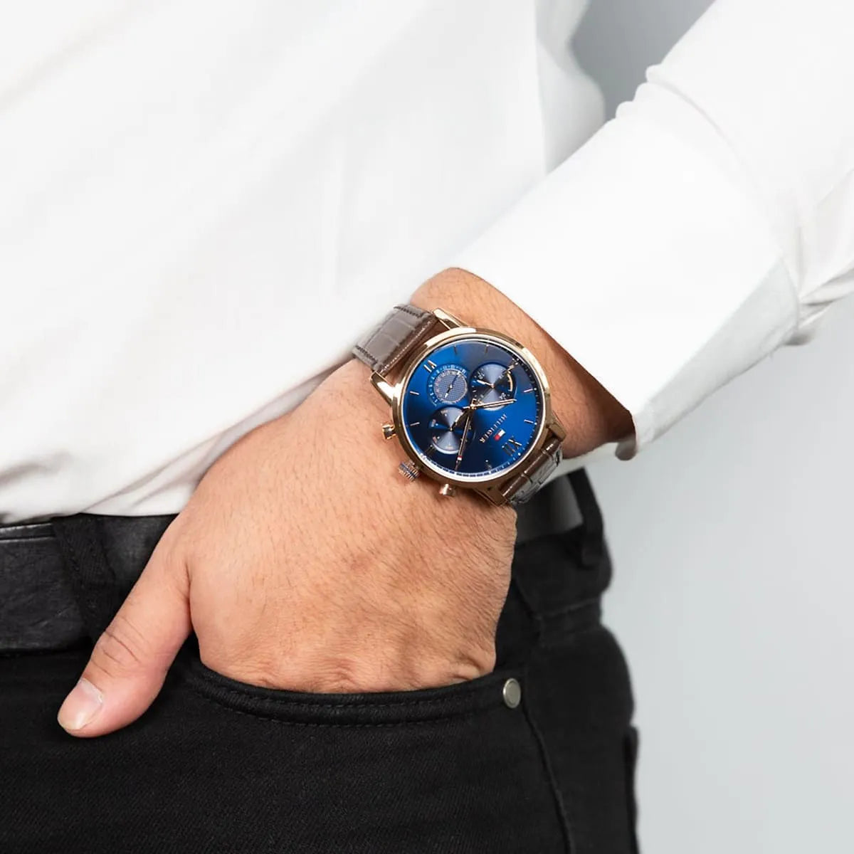 Tommy Hilfiger men's watch on wrist with navy blue chronograph dial and brown leather band