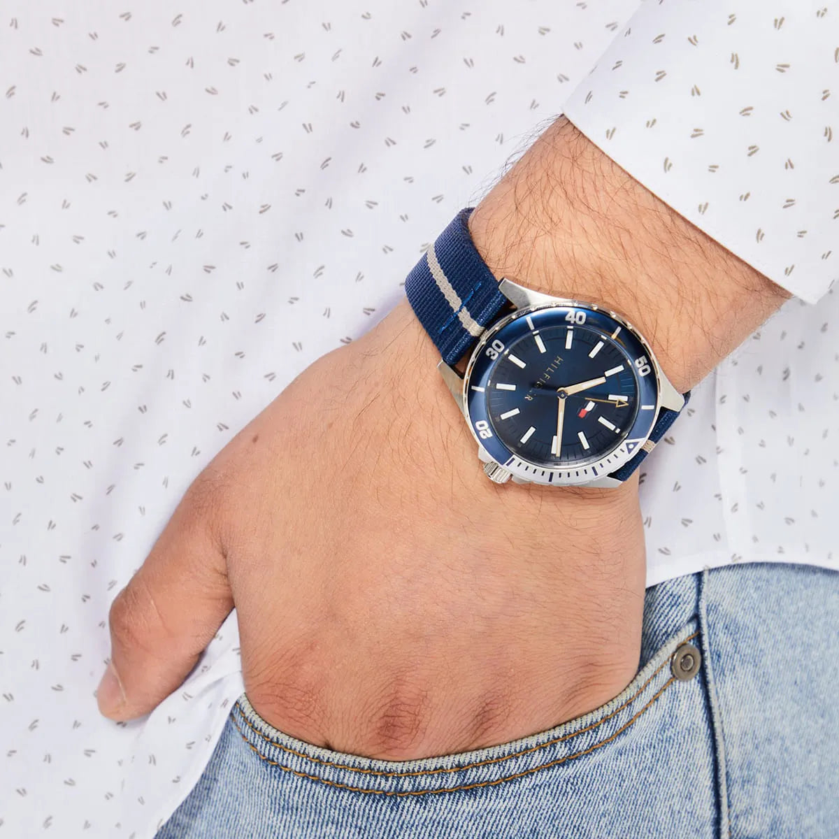 Tommy Hilfiger Logan watch worn on wrist with navy striped fabric strap