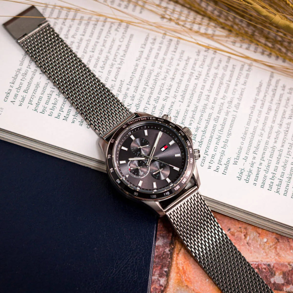 Tommy Hilfiger Miles watch displayed on magazine with steel mesh bracelet