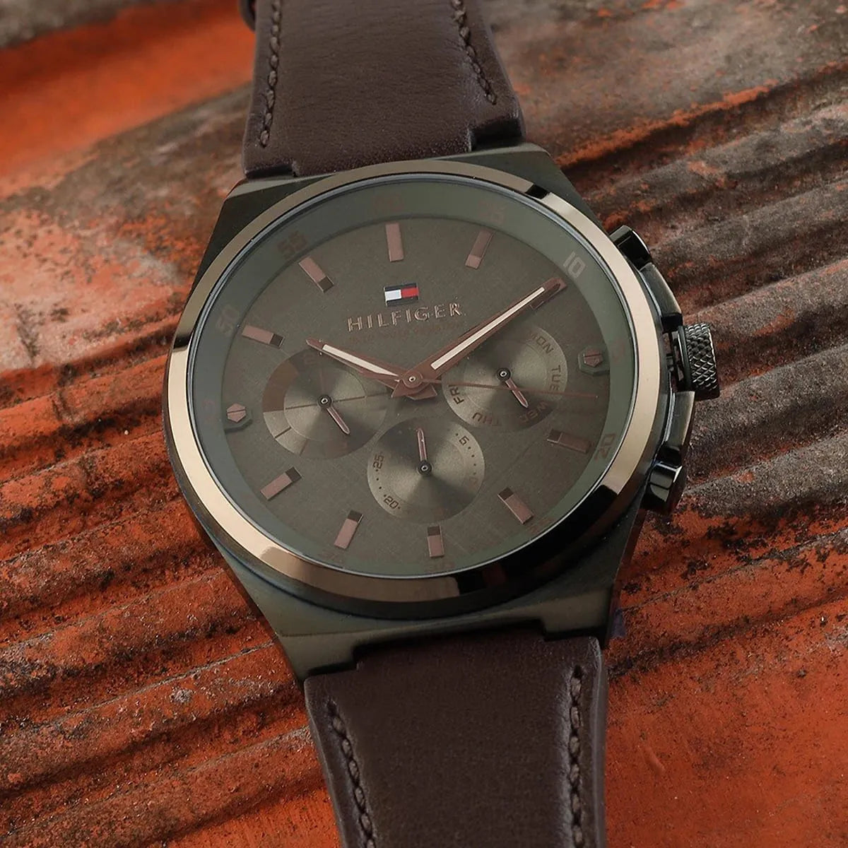 Tommy Hilfiger green dial chronograph watch on wrist with brown leather strap