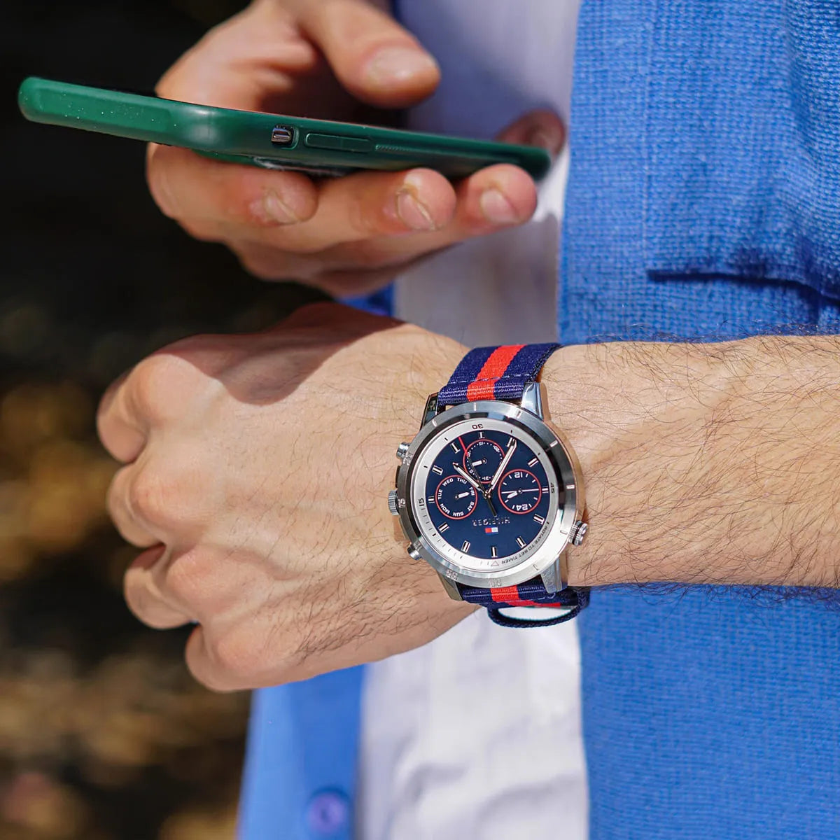 Tommy Hilfiger chronograph watch worn on wrist with blue dial and red accents visible