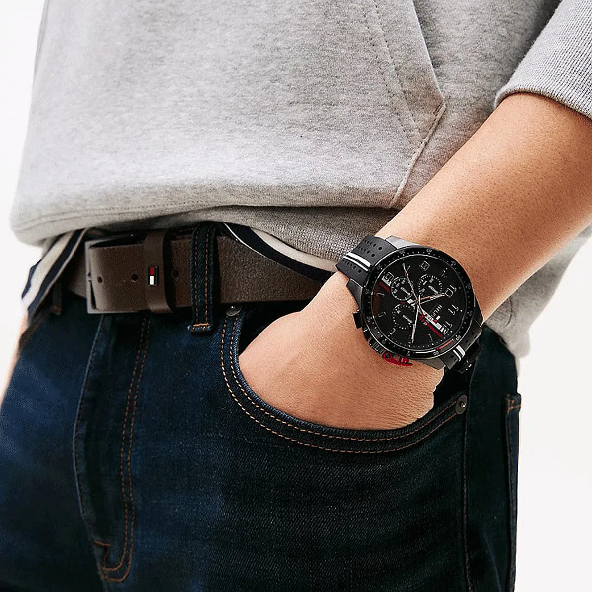 Tommy Hilfiger black chronograph watch on wrist with grey sweater and jeans