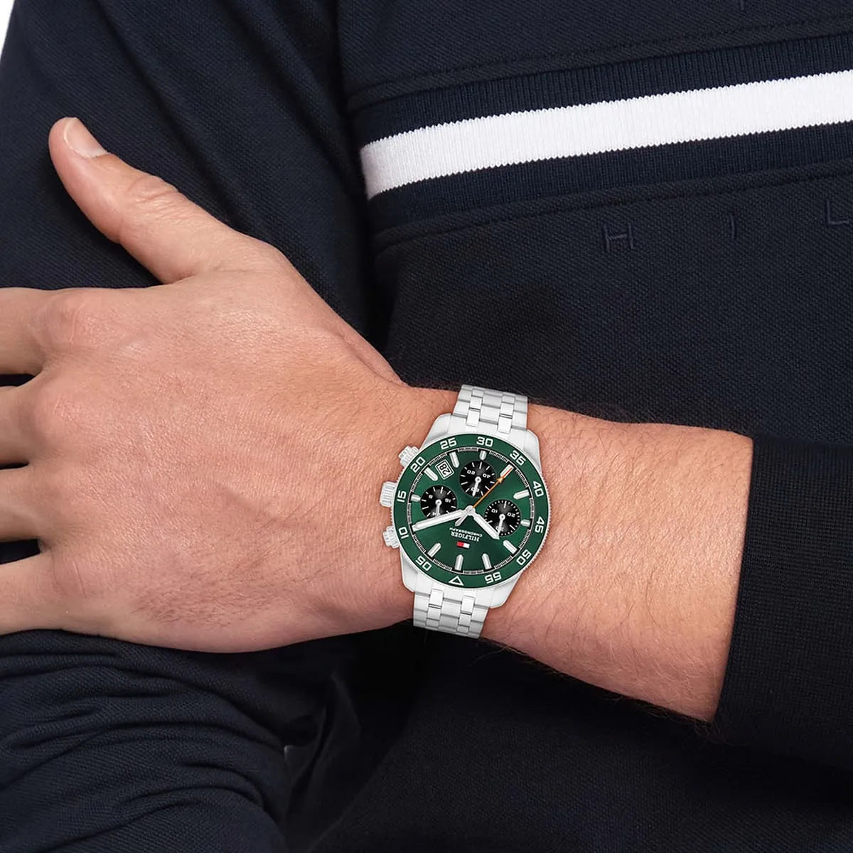 Tommy Hilfiger green dial chronograph watch worn on wrist with stainless steel bracelet