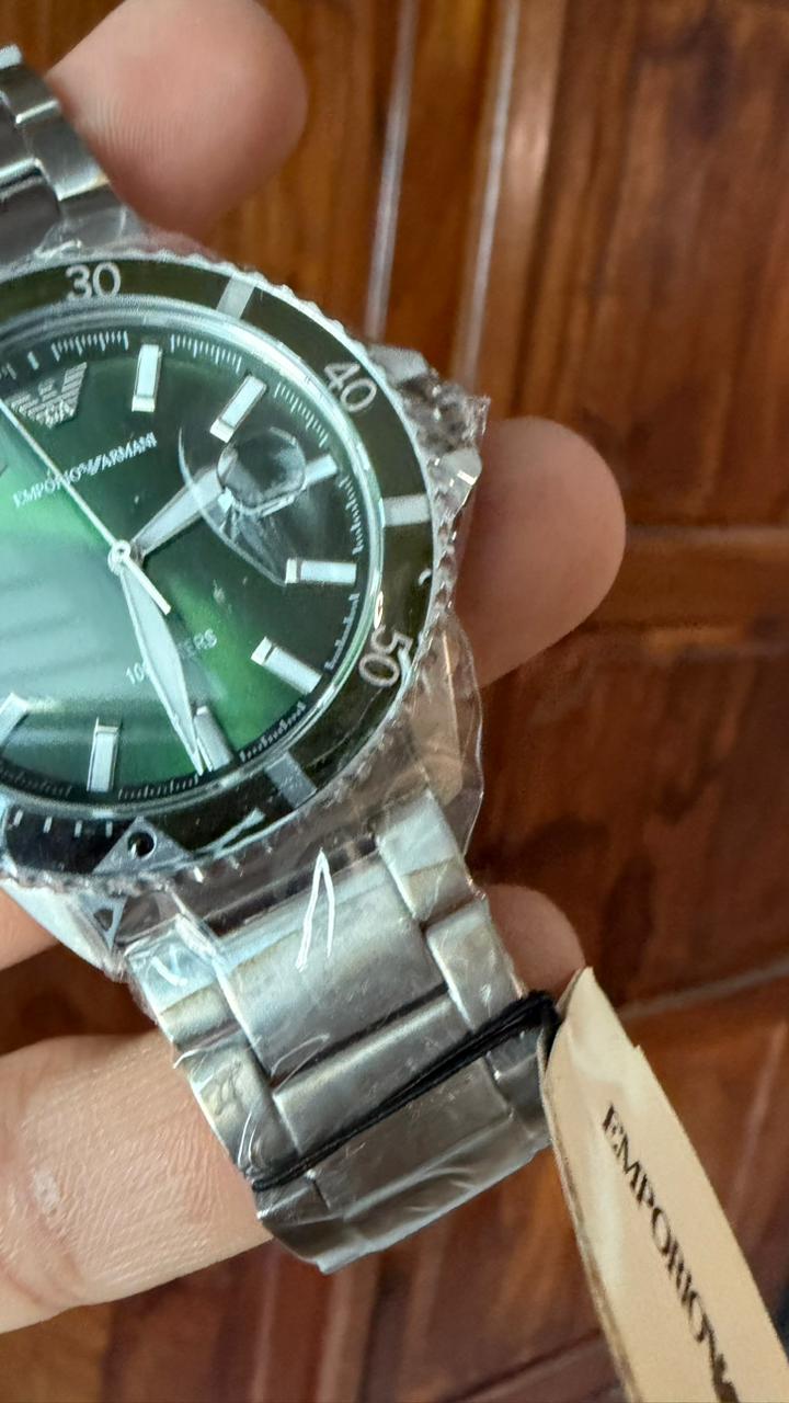 Emporio Armani AR11338 green dial close-up showing hour markers, hands, and date window