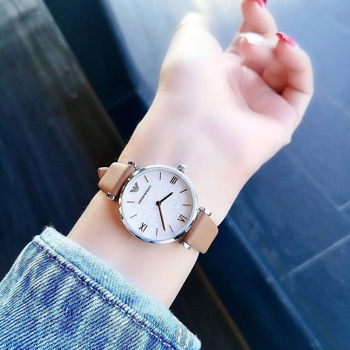 Emporio Armani AR1988 worn on wrist showing white dial with Roman numerals and brown leather strap