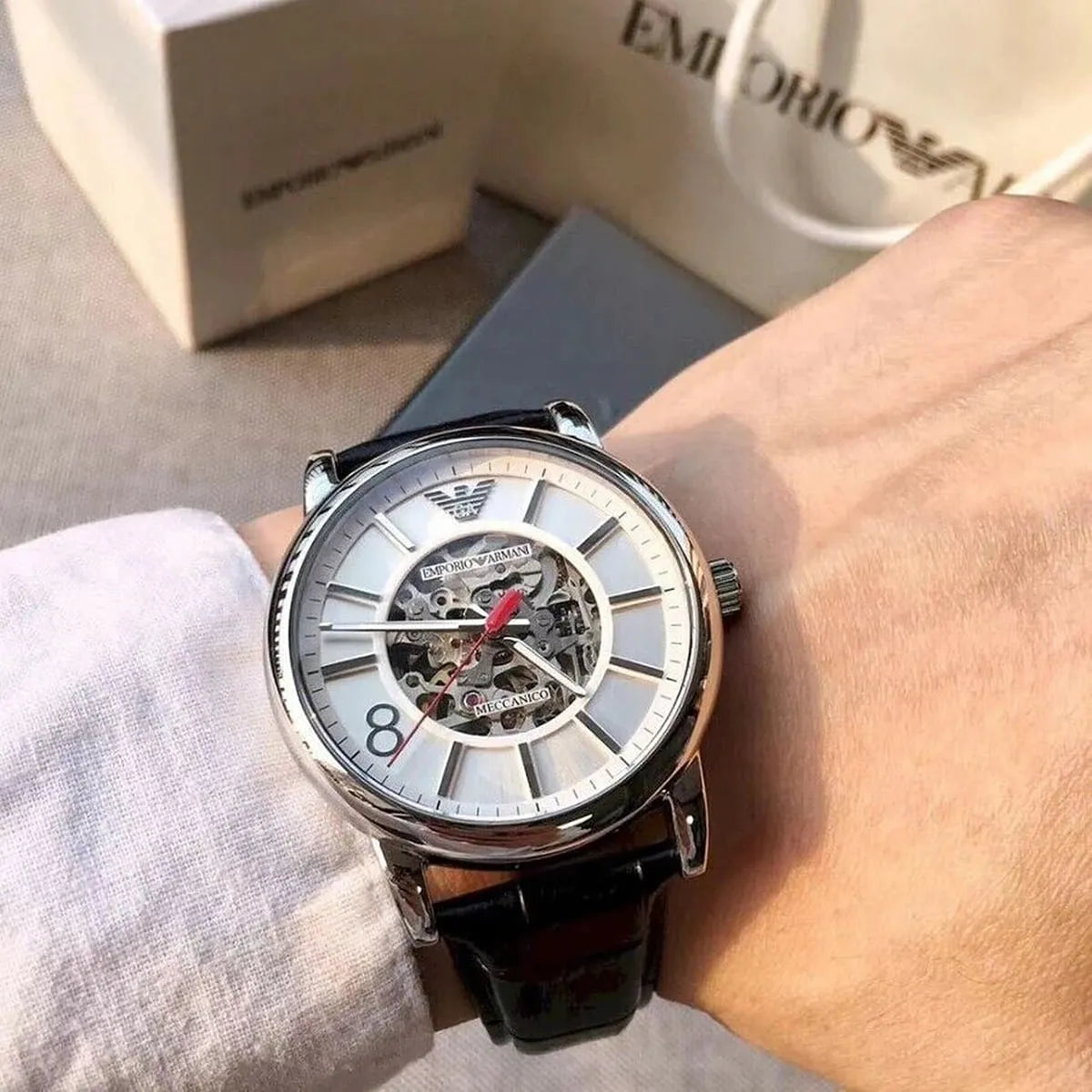 Emporio Armani Meccanico AR1997 watch on wrist with packaging visible in background