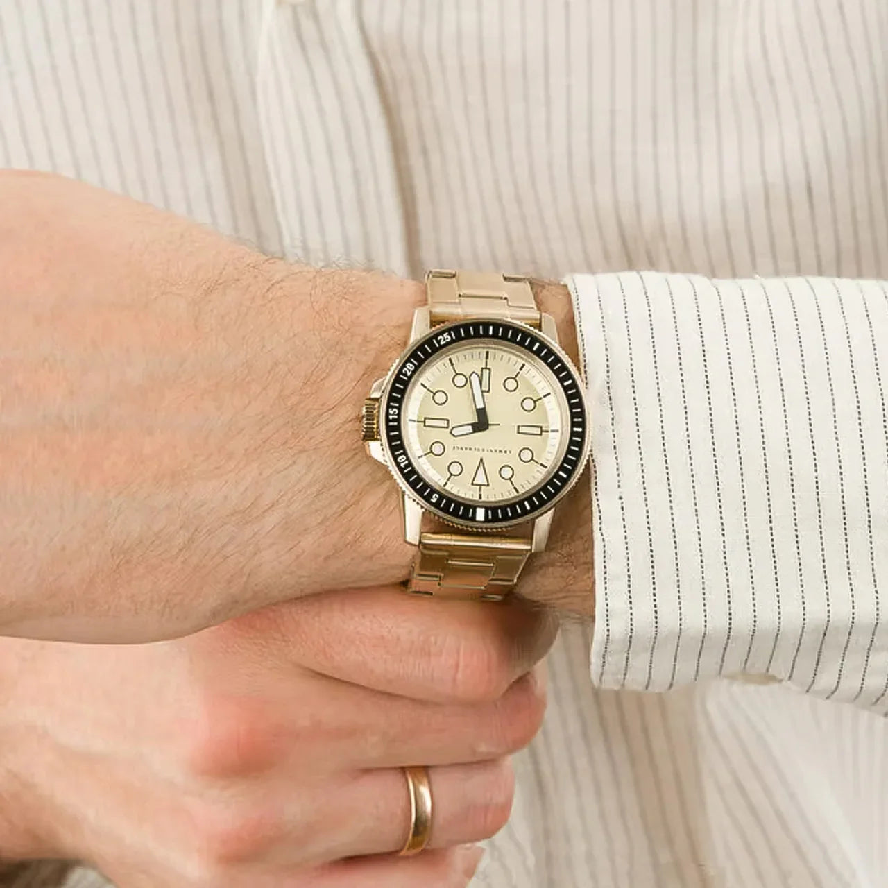 Armani Exchange Leonardo gold watch worn on wrist with cream dial and black bezel