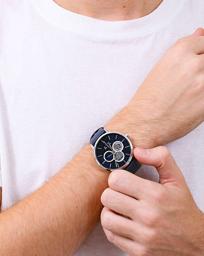 Armani Exchange Cayde multifunction watch worn on wrist showing blue dial and leather strap