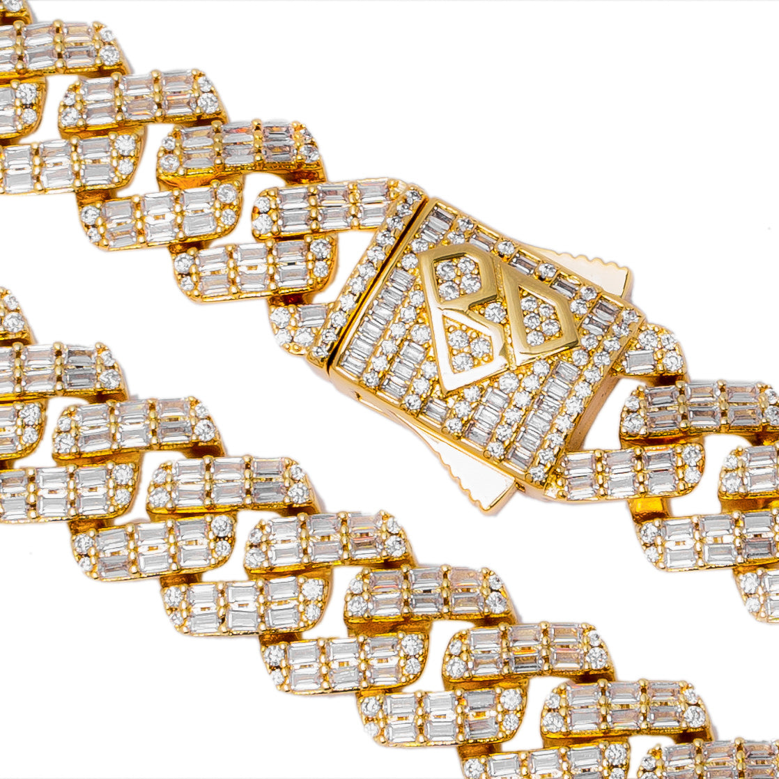 Close-up detail of Cuban link segments showing baguette diamond prong settings in gold