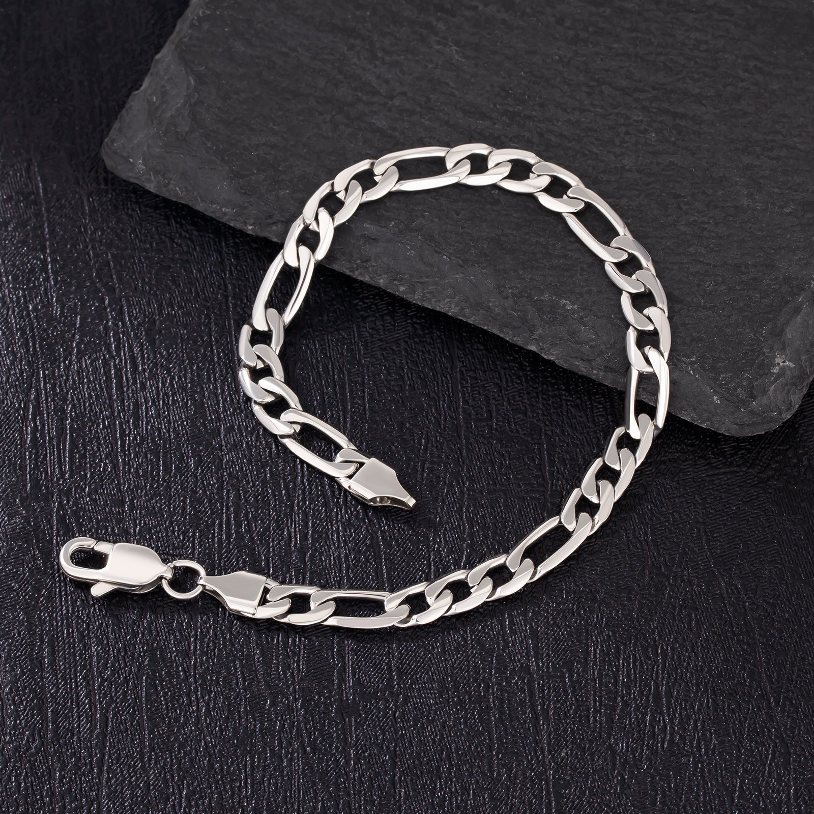 6mm steel figaro silver bracelet detail on dark slate surface with clasp visible