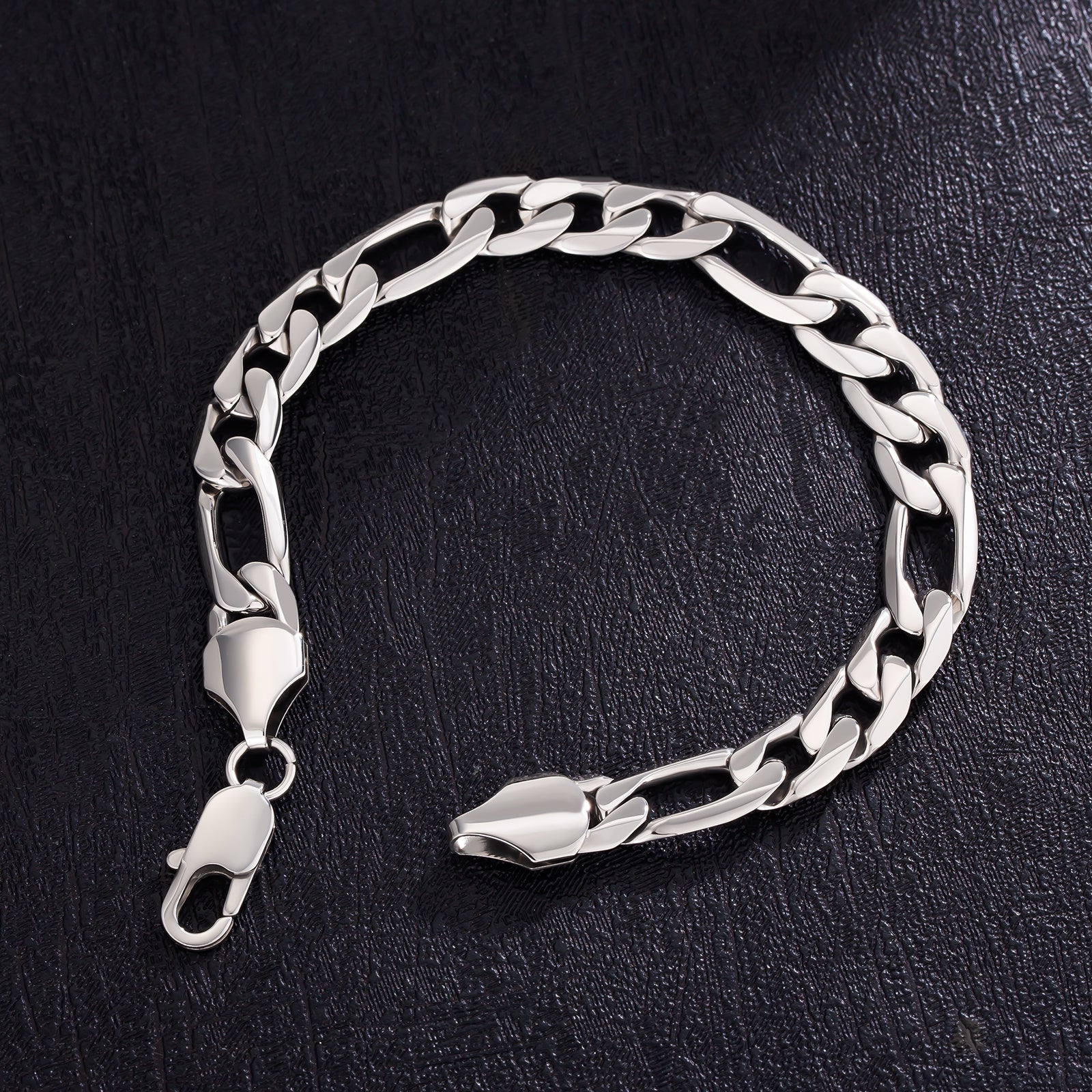 9mm Figaro steel bracelet with open lobster clasp on dark textured surface