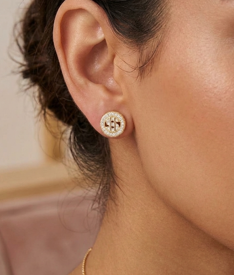 Gold dollar sign cluster earring worn on ear, showing cubic zirconia details