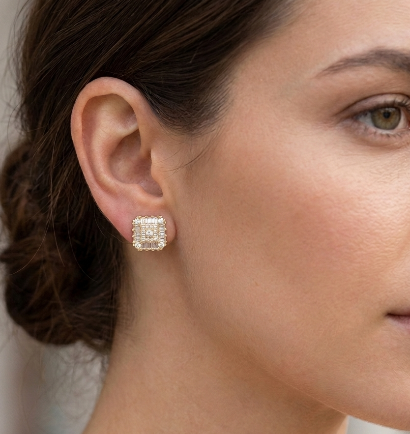 Woman wearing gold cushion-cut diamond stud earring on ear