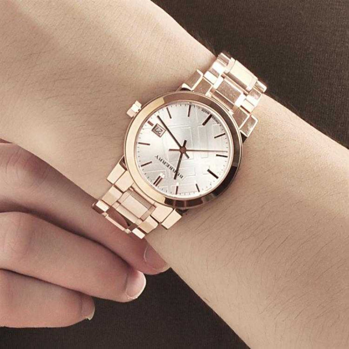 Burberry rose gold watch with white dial worn on wrist