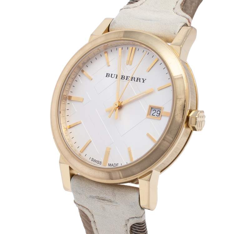 Angled view of Burberry The City watch showing white dial, gold indices, and beige leather strap