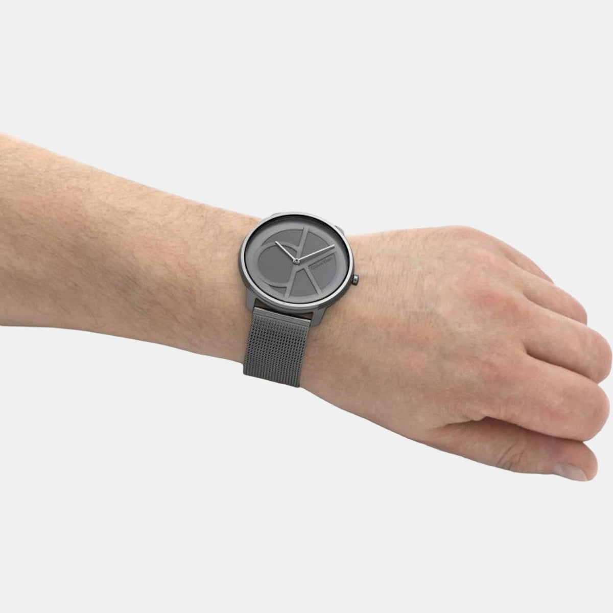 Calvin Klein quartz watch worn on wrist with grey dial and mesh band